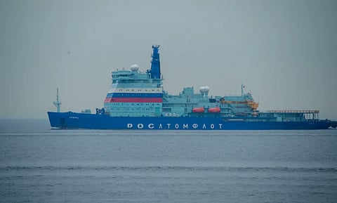 A powerful icebreaker ship navigates the open ocean, displaying robust engineering and maritime capabilities.
