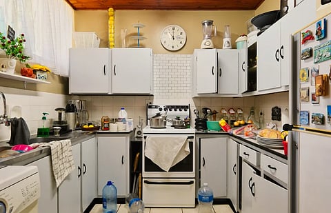 A homey and cluttered kitchen setup with appliances and decor.
