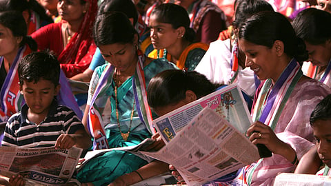 Women and children reading newspapers