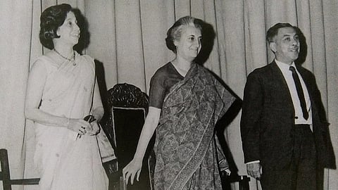 इस तस्वीर में इंदिरा गांधी दिखाई दे रही हैं। उनके दोनों ओर दो नेता खड़े हैं, एक महिला नेता और एक पुरुष नेता। इस तस्वीर में इंदिरा गांधी बहुत खुश नज़र आ रही हैं।