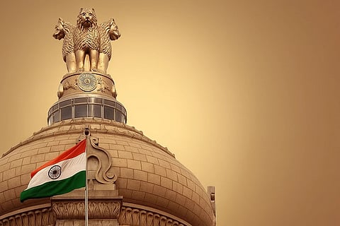 भारत का झंडा और उसके पीछे अशोक स्तम्ब बने हुए 
