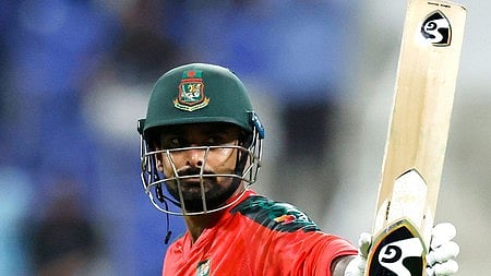 क्रिकेटर हाथ में बात लिए है 