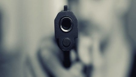 एक हाथ में बन्दूक है 