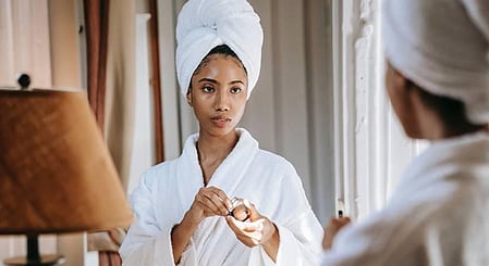 एक लड़की सफ़ेद रंग का बाथरोब पहनी है 