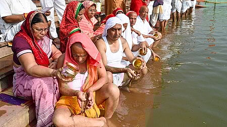 बहुत सारे लोग नदी के किनारे बैठे है 