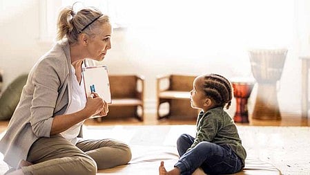 एक माँ अपने बच्चे के साथ बैठी है 