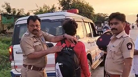 दो पुलिस ऑफिसर एक इंसान के पीछे बैग को पकड़े खड़े है।  
 