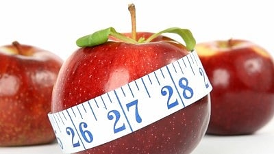  तीन लाल रंग का सेव वाइट रंग में मेज पर रखा है 