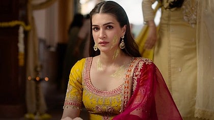 पिले रंग के सूट में कृति सेनन बैठी है 