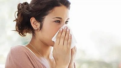 एक महिला अपनी नाक को छूते हुए नजर आ रही है|