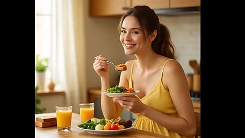 एक लड़की दो ग्लास जूस और हेल्दी फूड के साथ प्लेट में, हाथ में चम्मच लिए।