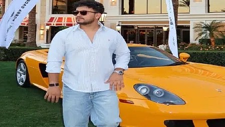 एक आदमी कार के पास खड़ा है|