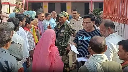 बिहार चुनाव 2025: मतदान केंद्र पर वोट डालते लोग, पुलिस और फौजी तैनात सुरक्षा में।