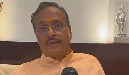 एक व्यक्ति रैली में बोलते हुए नजर आ रहा है।