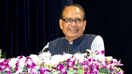 एक आदमी चुनावी कार्यक्रम में पोडियम पर खड़ा भाषण देते हुए।