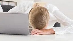 सिर झुकाकर चिंतित महिला बैठी हुई|