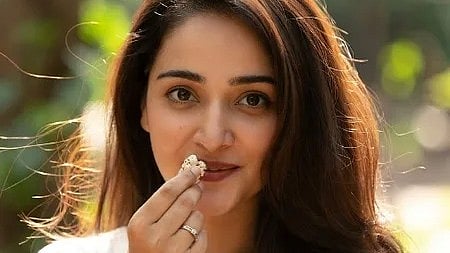 एक लड़की हाथ में मखाना लेकर हेल्दी स्नैक दिखा रही है।