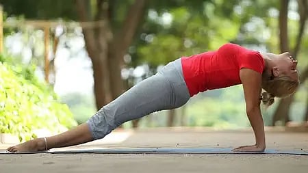 एक लड़की पूर्वोत्तानासन योग आसन करती हुई|