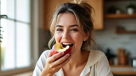 एक लड़की सेब खाती हुई, स्वास्थ्य और ऊर्जा के लिए।