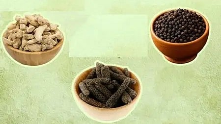 तीन कटोरियों में रखी काली मिर्च, अदरक और अन्य आयुर्वेदिक सामग्री वाली तस्वीर।