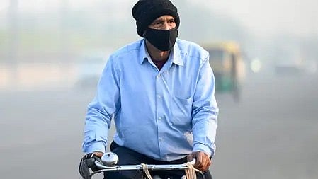 दिल्ली-एनसीआर में बढ़ते प्रदूषण के बीच मास्क पहने व्यक्ति।