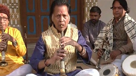 अयोध्या में राममंदिर ध्वजारोहण के दौरान एक आदमी बांसुरी बजा रहा है, जबकि अन्य लोग शहनाई और अन्य वाद्ययंत्र बजा रहे हैं।
