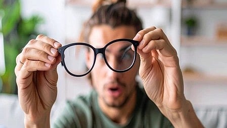 सर्दियों में चश्मा देखकर हैरान व्यक्ति, फोटो थोड़ी धुंधली|