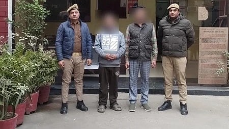 दो पुलिसकर्मी दो गिरफ्तार अपराधियों के साथ खड़े हुए|