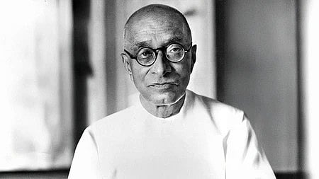 एक बुज़ुर्ग आदमी की तस्वीर, गंभीर और सोचते हुए नजर आ रहे हैं।