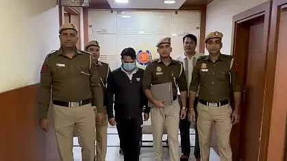 चार पुलिसकर्मी एक क्रिमिनल को पकड़े हुए खड़े हैं।
