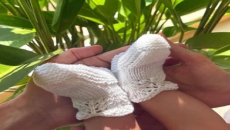 हाथों में बच्चे के पैर नजर आ रहे हैं|