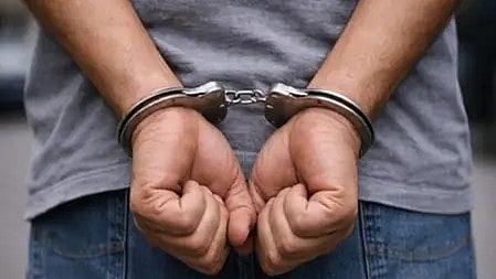 जम्मू में गिरफ्तार ड्रग तस्कर, हाथ में हथकड़ी लगी हुई।