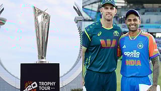 टी20 वर्ल्ड कप 2026 ट्रॉफी स्टैंड पर रखी हुई, साथ में मैदान पर भारत के कप्तान सूर्यकुमार यादव और ऑस्ट्रेलियाई कप्तान मिचेल मार्श अपनी-अपनी जर्सी में साथ खड़े हैं 
