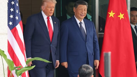 अमेरिका के राष्ट्रपति डोनाल्ड ट्रंप और चीन के राष्ट्रपति शी जिनपिंग एक साथ खड़े दिखाई दे रहे हैं। उनके पीछे अमेरिकी और चीनी झंडे लगे हैं।