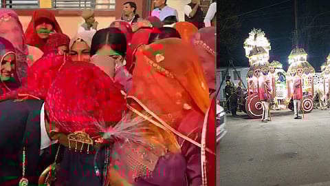 शादी की बारात से पहले पारंपरिक रस्म निभाते हुए दूल्हा लाल साफा पहनकर झुका हुआ है, उसके आसपास घूंघट ओढ़े महिलाएँ खड़ी हैं; दूसरी ओर रोशनी से सजी बारात की झांकी और सजाए गए घोड़े सड़क पर खड़े दिखाई दे रहे हैं।