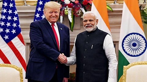 नरेंद्र मोदी और डोनाल्ड ट्रम्प हाथ मिलाते हुए और पीछे दोनों देशों का झंडा नज़र आ रहा है।  