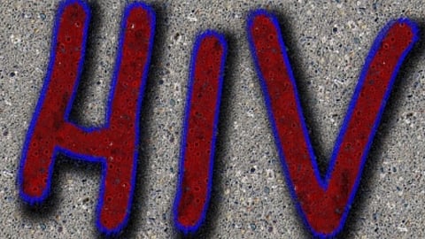 सिलेटी रंग के बैकग्राउंड पर लाल रंग से HIV लिखा है। 
