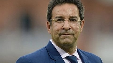 सफ़ेद शर्ट और नीले कोट में पूर्व क्रिकेटर वसीम अकरम 
