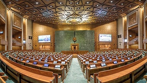 भारत के नए संसद भवन के लोकसभा कक्ष का अंदरूनी दृश्य। इसमें लकड़ी की बेंचें, हर डेस्क पर डिजिटल स्क्रीन और छत पर मोर के पंखों से प्रेरित खूबसूरत नक्काशी दिखाई दे रही है।