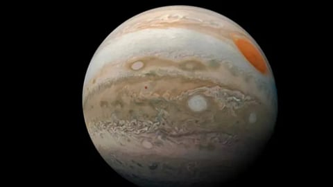 अंतरिक्ष के काले बैकग्राउंड में बृहस्पति ग्रह (Jupiter) का दृश्य। ग्रह की सतह पर भूरे, सफेद और नारंगी रंग की धारियाँ और गैस के विशाल तूफान दिखाई दे रहे हैं।