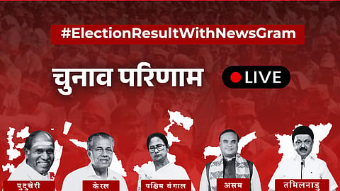 सबसे ऊपर "#ElectionResultWithNewsGram" लिखा है, सफेद अक्षरों में "Results LIVE" और एक लाल बिंदु है। नीचे पांच व्यक्तियों के चित्र हैं, जिनमें से प्रत्येक को अलग-अलग राज्यों - पुडुचेरी, केरल, पश्चिम बंगाल, असम और तमिलनाडु - के नाम से दर्शाया गया है, साथ ही राज्य मानचित्रों की आकृतियाँ भी हैं
