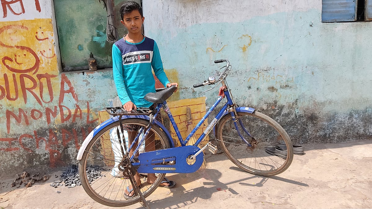 Surja Mondol with the cycle his aunt  bought with the money given to her under the Kanyashree scheme.