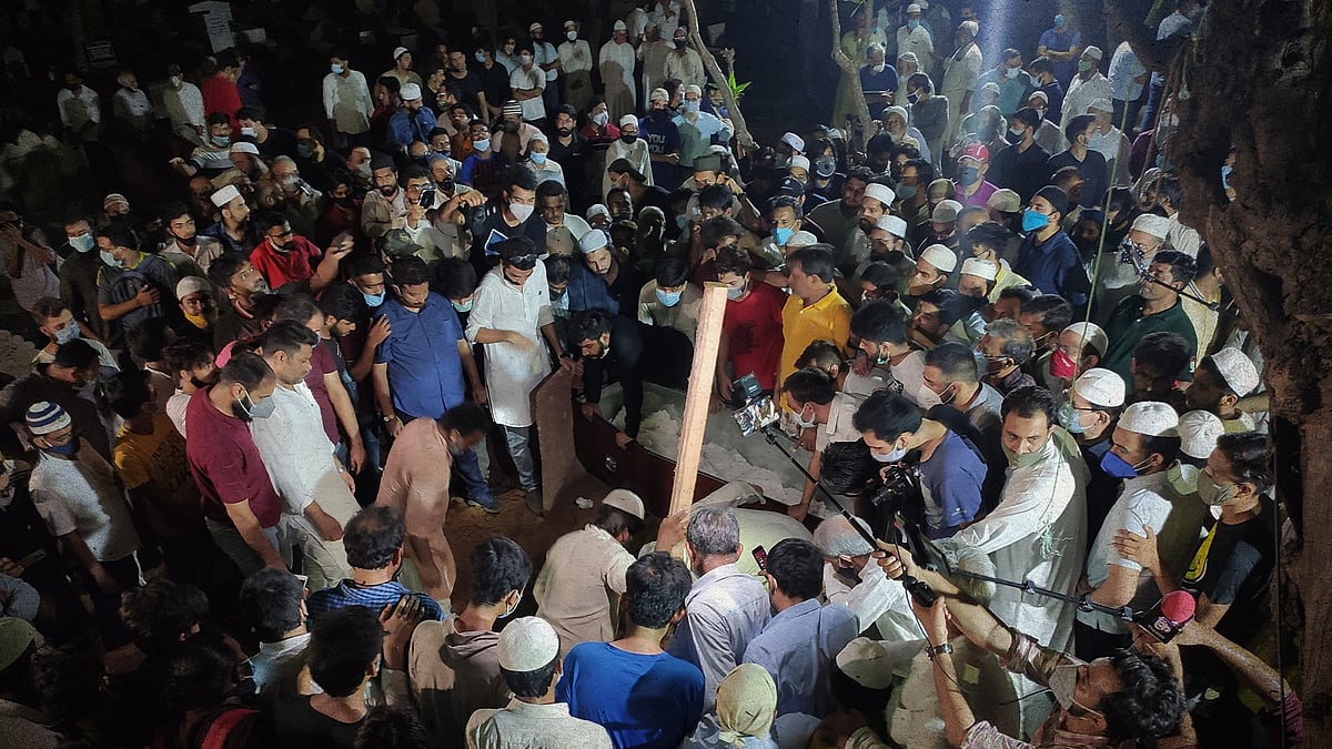 Attendees gather around as Siddiqui is laid to rest at the cemetery.