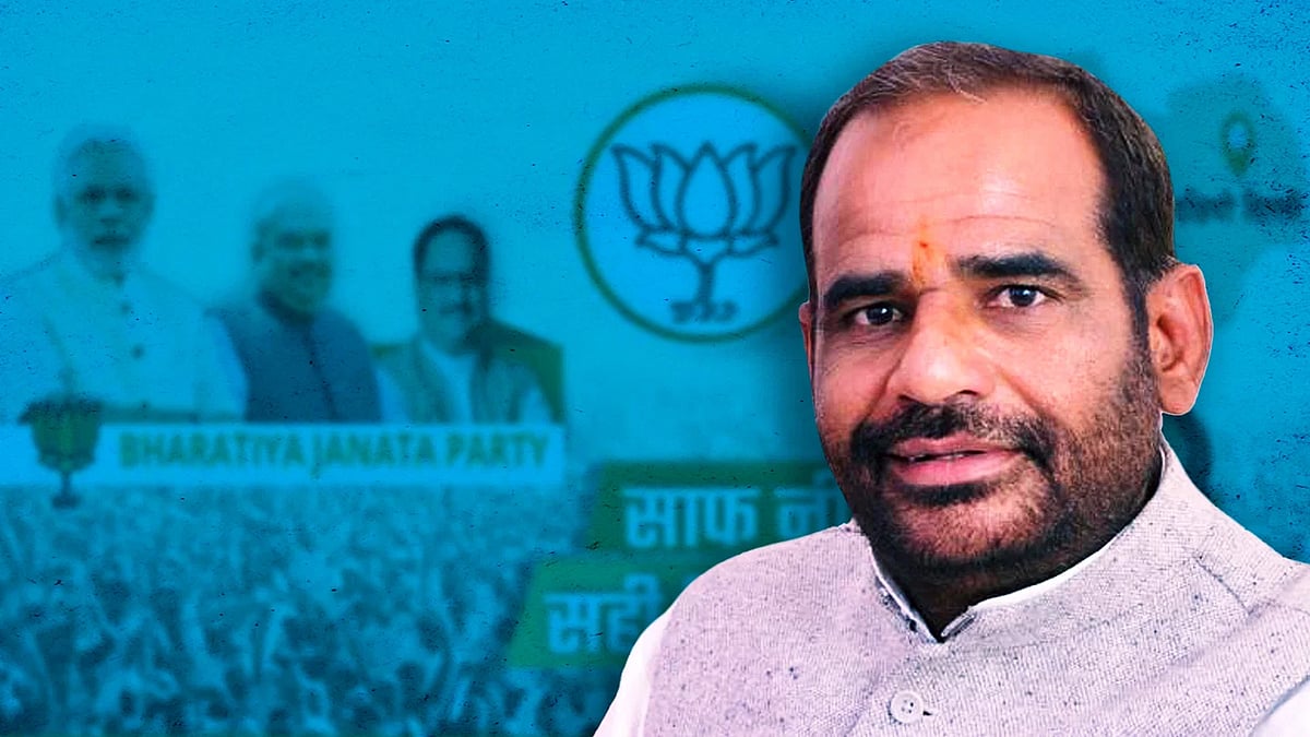 Ramesh Bidhuri with BJP posters behind him.