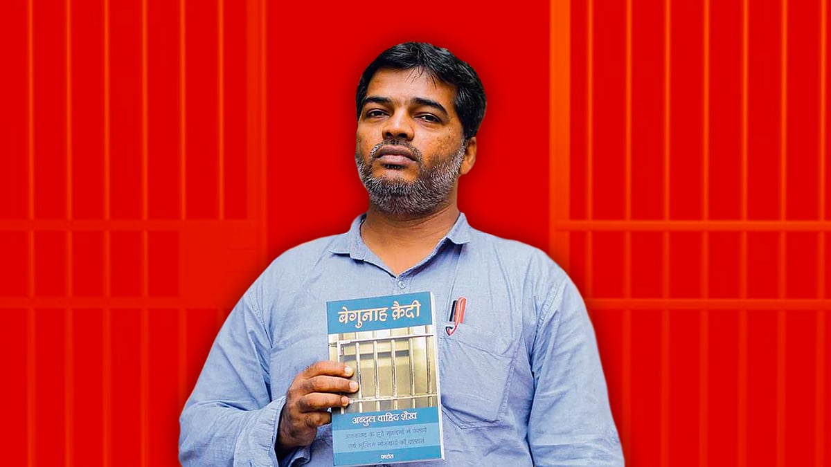 Wahid Shaikh holding his book which detailed his experience in jail.