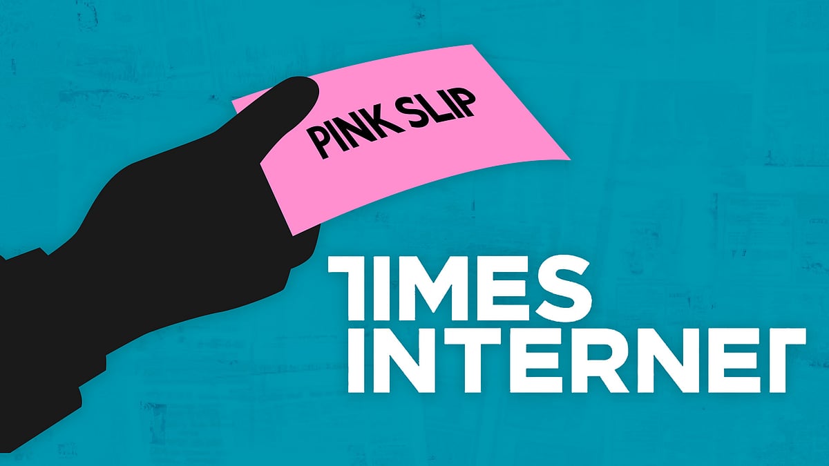 A hand holds a pink slip with the Times Internet logo in the background.