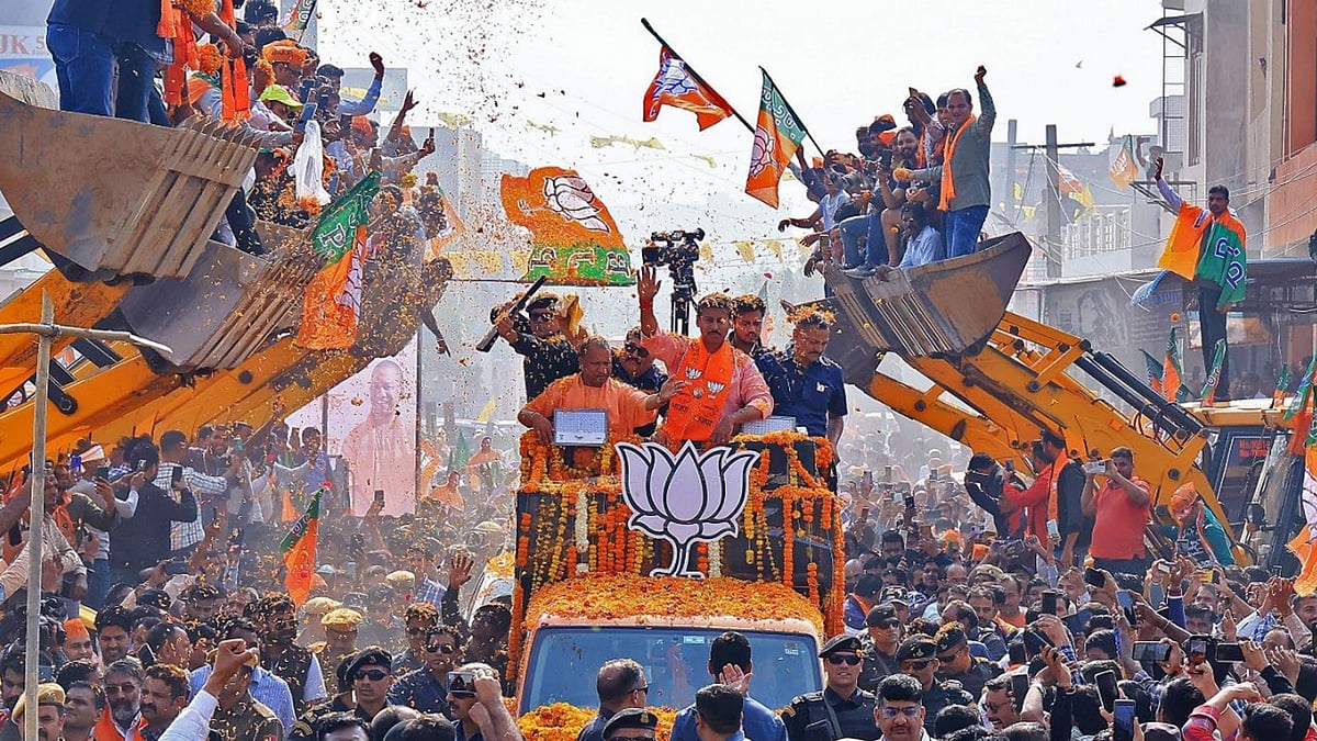 UP CM Yogi Adityanath atop a truck and his supporters on JCB bulldozers during a rally.