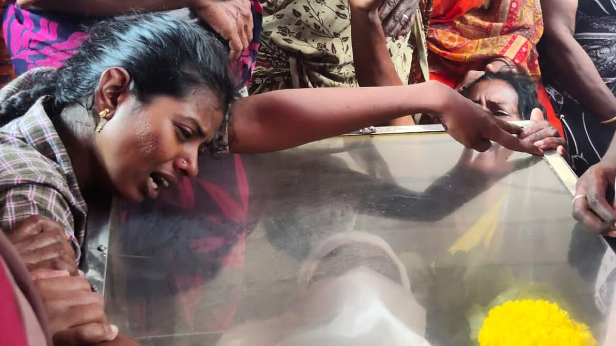 Sharmila clings on to the casket with her husband Praveen's mortal remains. 