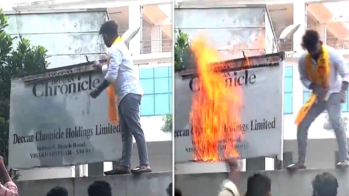 A TDP workers setting a display board on fire on the Deccan Chronicle's office premise.