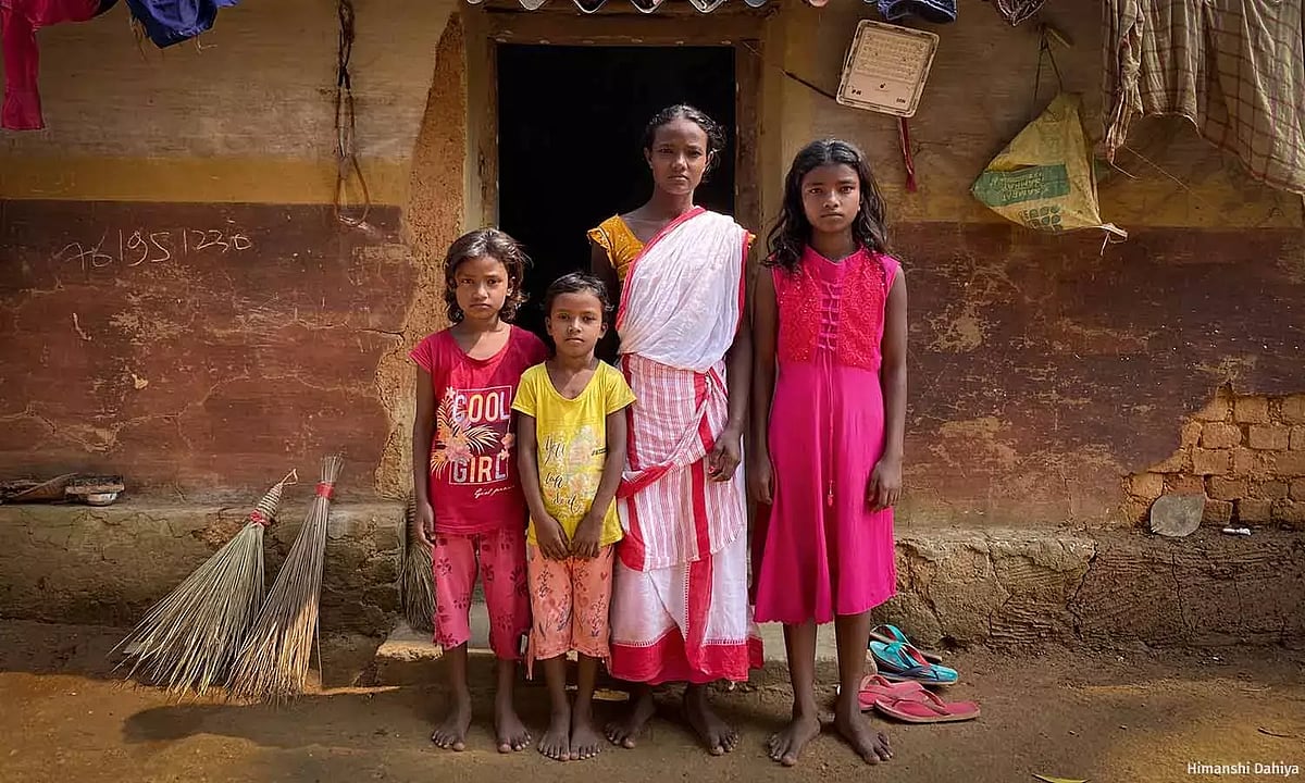 झारखंड के सरायकेला-खरसावां जिले के रसुनिया गांव में अपने घर पर मुंगली अपनी बेटियों के साथ.